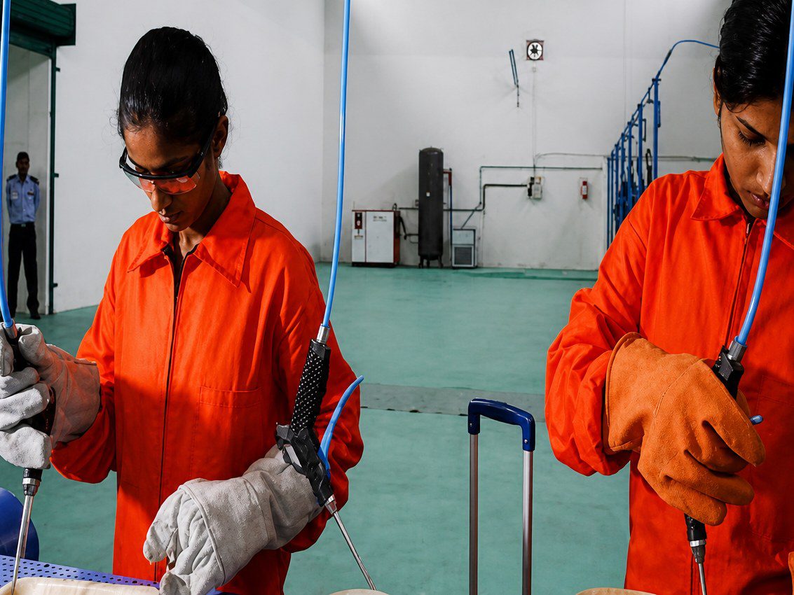 Ecodyne Tableware worker in PPE operating pneumatic press equipment at the Karnataka manufacturing facility for areca palm leaf plate production