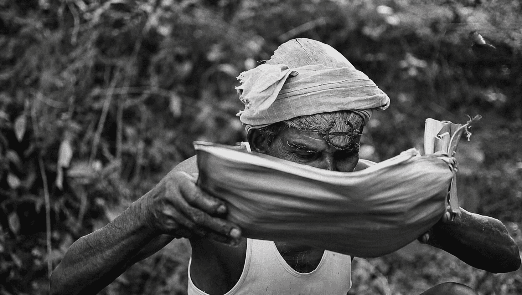 Elderly Indian man eating from a folded leaf