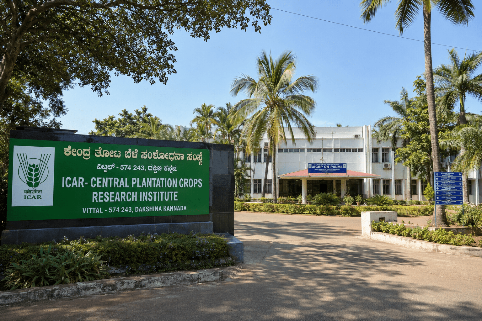 ICAR-Central Plantation Crops Research Institute (CPCRI) Vittal regional station entrance at Dakshina Kannada, Karnataka (PIN 574 243) — the scientific partner of Conservia Partners in the seven-year palm leaf organic farming programme effective 2 February 2019, with AICRP on Palms research banner visible.